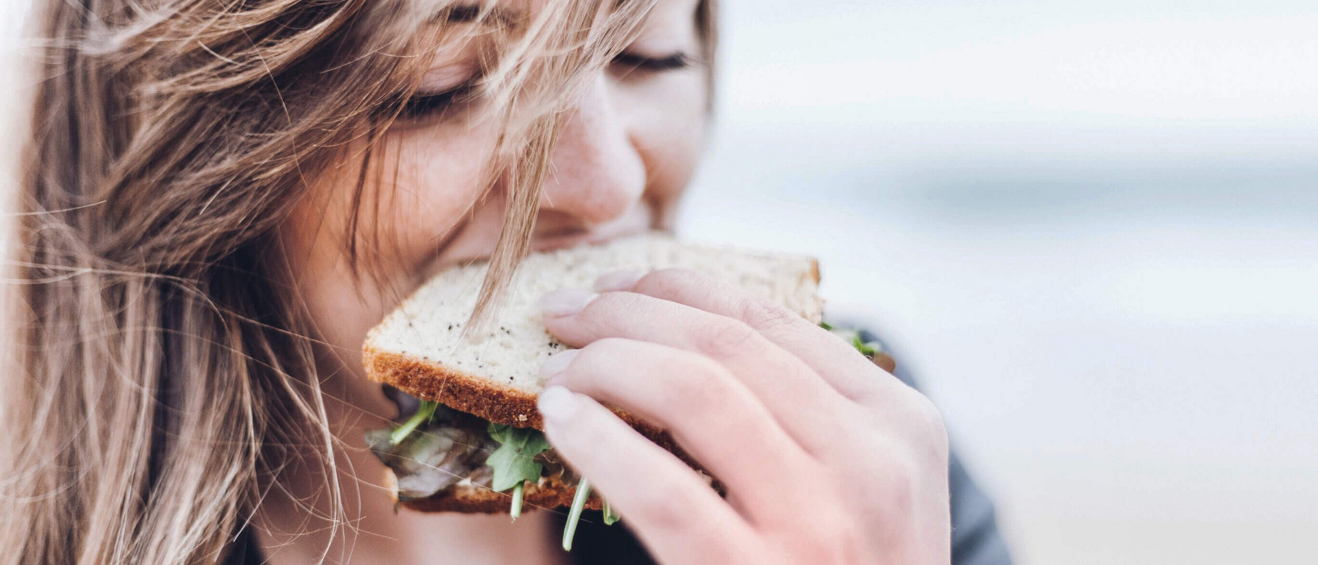 Frau beißt in gesundes Sandwich