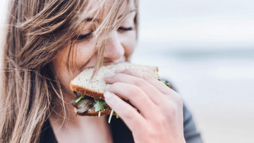 Frau beißt in gesundes Sandwich