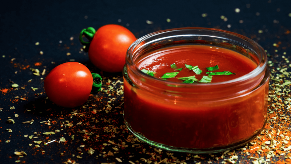 Schale mit roter Flüssigkeit und Tomaten daneben